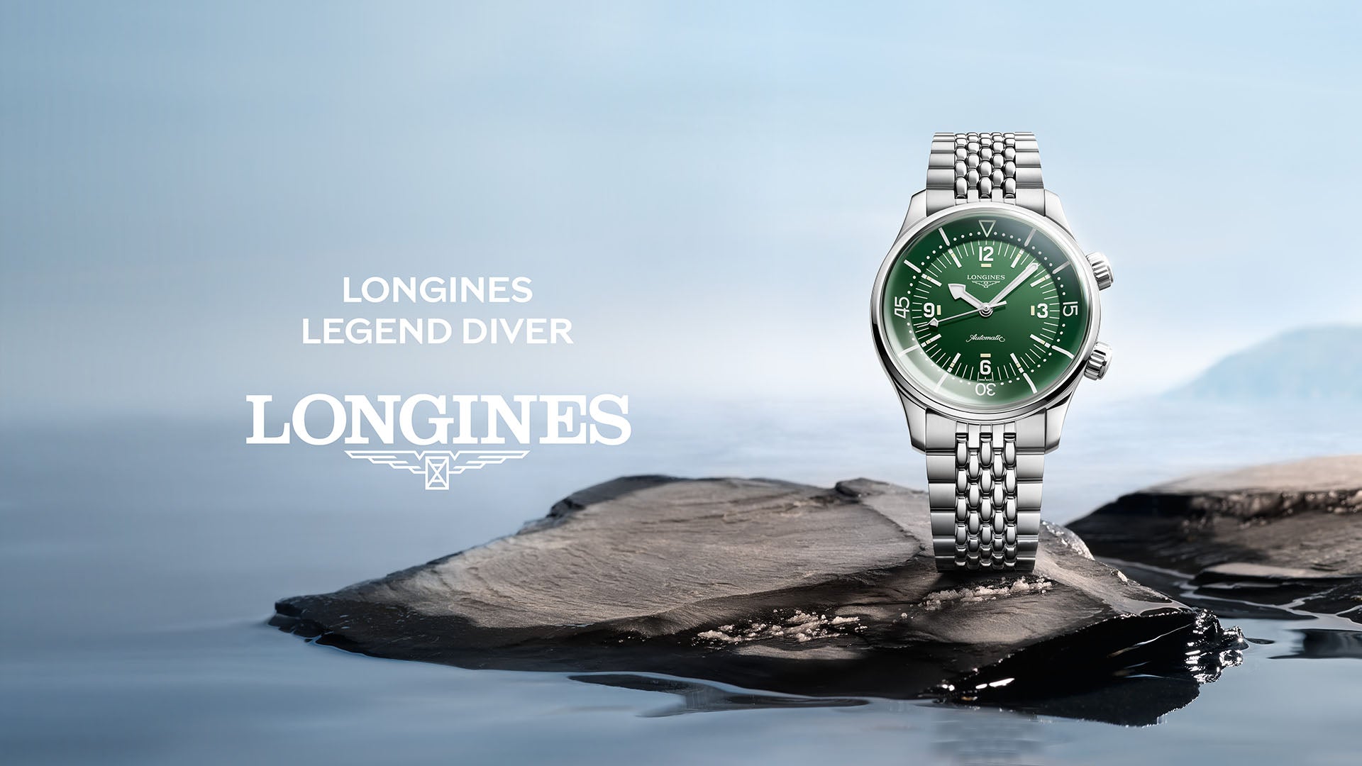 Longines Legend Diver Uhr mit grünem Zifferblatt und Edelstahlarmband auf nassem Felsen vor Wasserlandschaft